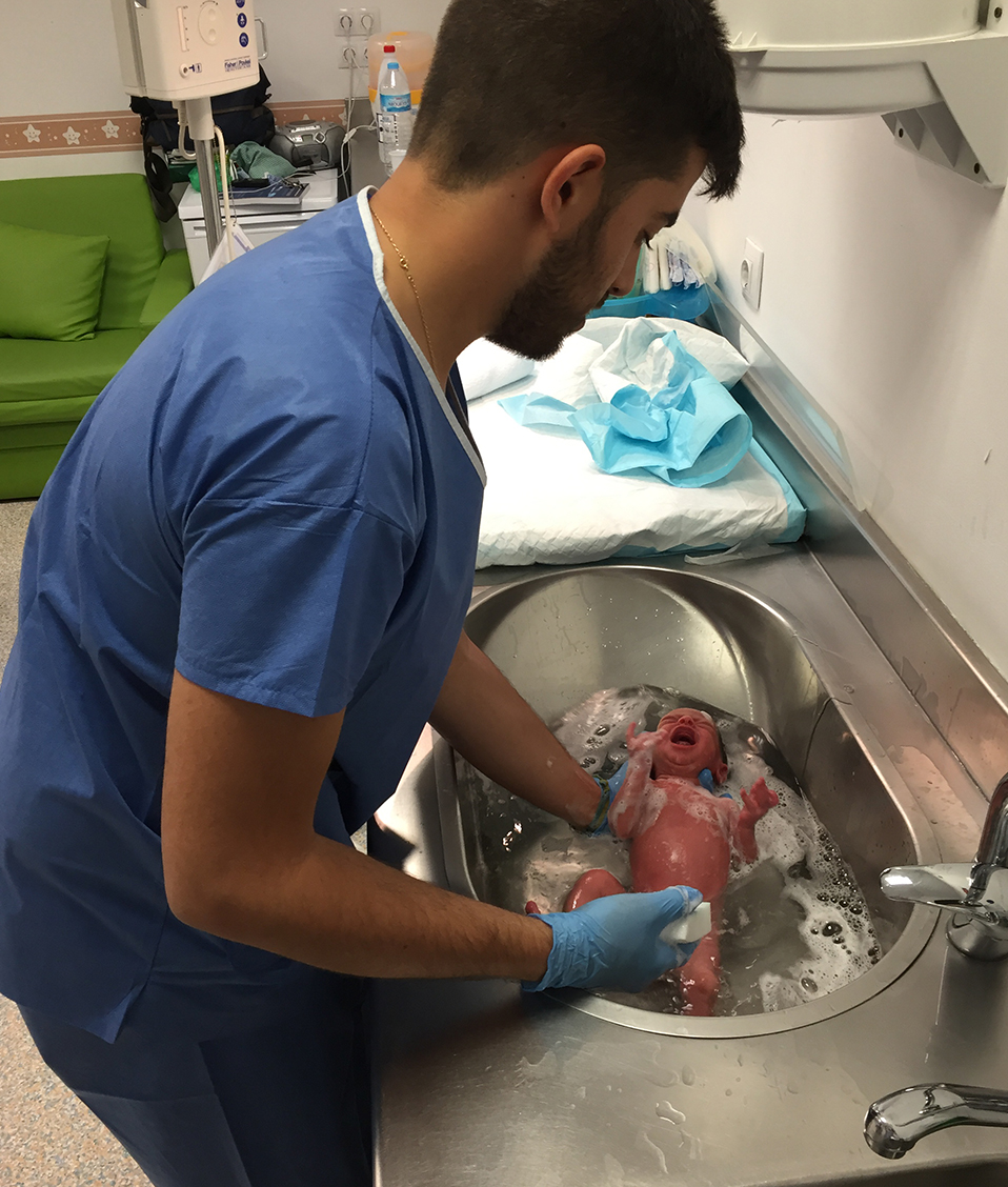 Enfermero bañando un bebé recién nacido